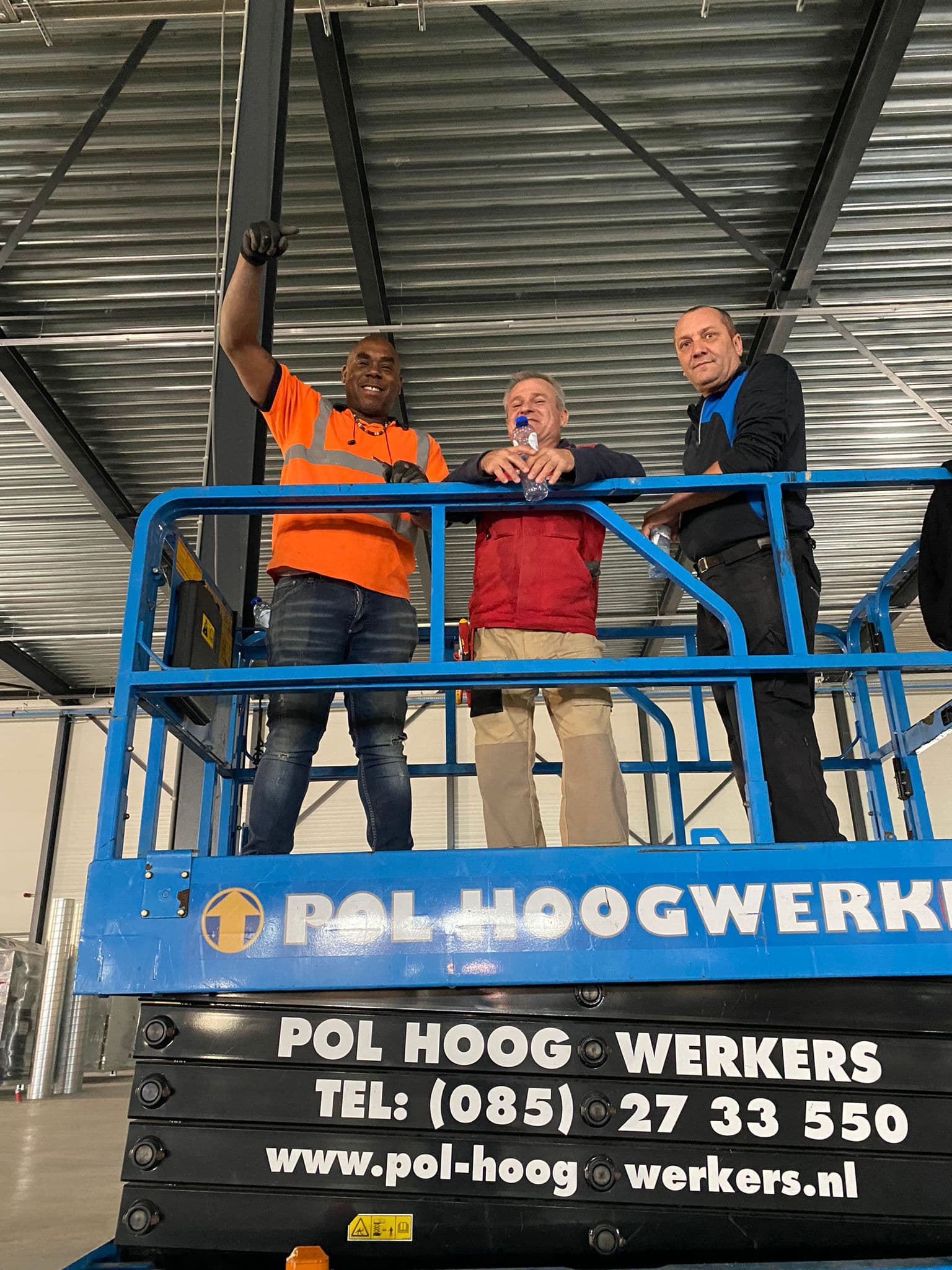 Drie vakmensen op een hoogwerker tijdens een projectbezoek van Volt